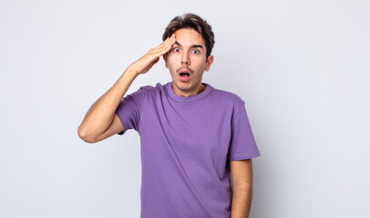 young handsome hispanic man looking happy, astonished and surprised, smiling and realizing amazing...