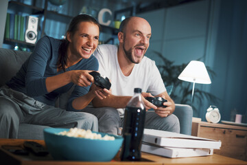 Happy couple playing video games at home