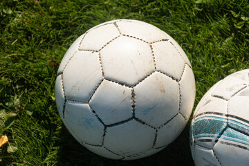 Practice soccer ball sits on the sideline while a game is underway.