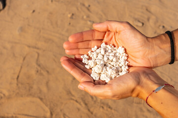 A young woman with stones in her hand on Popcorn Beach near the town of Corralejo, north of the island of Fuerteventura, Canary Islands. Spain