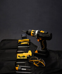 Cordless drill - screwdriver with drill. Construction tools set. Black background. Goods for...