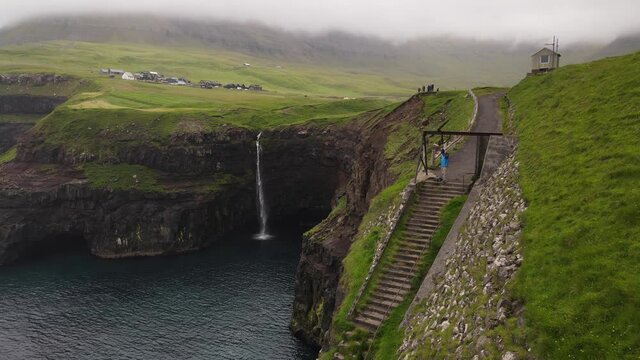 Beautiful cinematic aerial footage of Gasadalur waterfall and village and landscapes in the Faroe Islands	