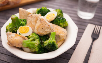 chicken breast with broccoli and quail eggs on plate for healthy dinner