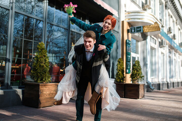 the young guy carries the bride in his arms. happy marriage,