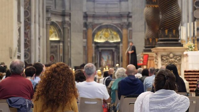 People listen to priest at catholic cathedral during pandemic.