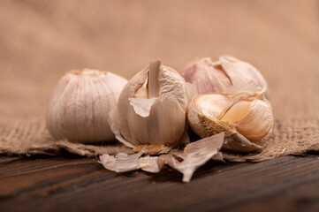 Heads of young garlic on a table covered with burlap, close-up, selective focus.