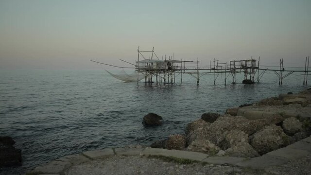 View of the sed at the sunset, Adriatic sea, rocs and sand of the italian coast. View of an old trebuchet