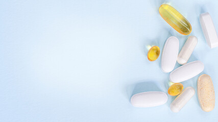 Blurred White and yellow pills spread on Blue. Health insurance concept.