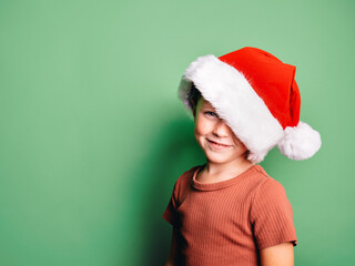 Smiling boy wearing Santa Claus hat standing in studio