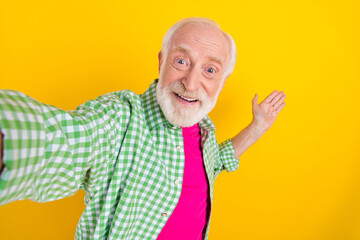 Self-portrait of attractive cheerful grey-haired man showing copy space welcome isolated over...