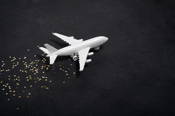 Toy white airplane with golden stars. Christmas concept of travel and delivery by plane, New Year