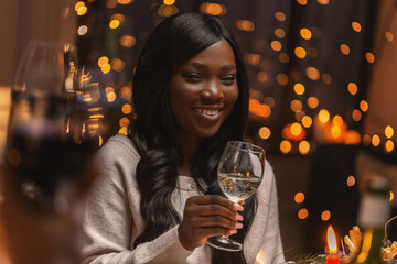 holidays, party and celebration concept - happy woman with glass of wine having christmas dinner at home
