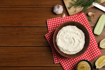 Delicious tartar sauce and ingredients on wooden table, flat lay. Space for text