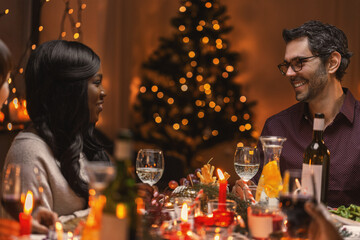 Obraz na płótnie Canvas holidays, party and celebration concept - happy friends having christmas dinner at home