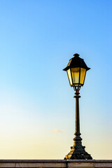 Fototapeta na wymiar Old colonial style lamppost on the walls of the streets of Salvador, Bahia during summer sunset.
