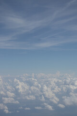 Fototapeta na wymiar View from the plane. Natural landscape and cumulus clouds. Beautiful blue sky