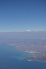Plakat View from the plane. Natural landscape and cumulus clouds. Sea view from above. Beautiful blue sea and sky