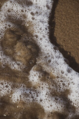 The wave crashed on the sandy beach. Wave foam. Beach landscape. Nature backgrounds