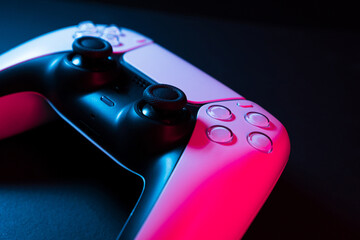 Next generation white game controller isolated on black background with colored lights illuminating...