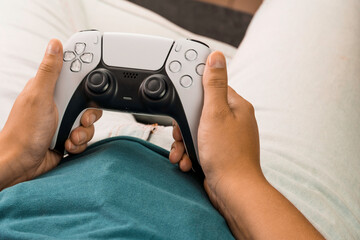 Girl holding a next generation white game controller while playing the game. © Diego