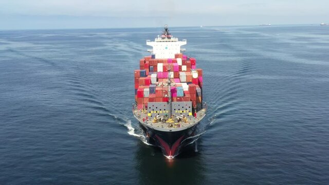 Aerial in front view of smart cargo ship carrying container from custom container depot go to ocean concept freight shipping by ship service on blue sky background.