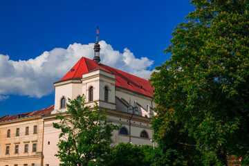 summer landmark city view green tree and catholic church building exterior travel Eastern Europe sightseeing destination point in June day time photo