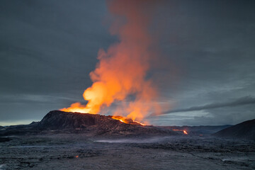 Night volcanic eruption. Fresh hot lava, flames and poisonous gases going out from the crater.
