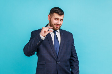 Handsome bearded businessman wearing official style suit showing a little bit gesture, small amount...