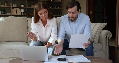 Nervous stressed millennial husband wife concerned with finance problems detect family budget deficit confused of too high business costs. Distressed family couple troubled with tax loan mortgage debt