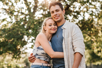 Fototapeta premium summer holidays, love and people concept - happy young couple hugging outdoors