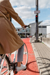 city transport and people concept - close up of woman with bicycle waiting for green traffic light...