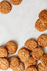 Homemade oatmeal cookies with sesame seeds on a gray concrete background top view. Tasty sweet breakfast, healthy food. Cookies background. Copy space. Flat lay