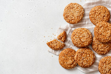 Homemade oatmeal cookies with sesame seeds on a gray concrete background top view. Tasty sweet breakfast, healthy food. Cookies background. Copy space. Flat lay