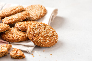 Homemade oatmeal cookies with sesame seeds on a grey background. Tasty sweet breakfast, healthy food. Copy space