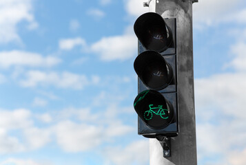 road and signals concept - close up of green traffic light for bicycle over blue sky