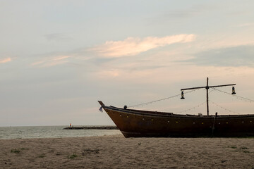 Fototapeta premium A fishing boat moored on the sandy beach in the morning.