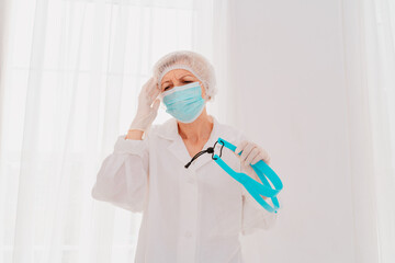 Fototapeta premium Doctor with face mask and face protector is tired about the covid-19 virus pandemic