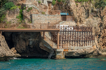 Cliffs with caves and stairs built in concrete, stone and metal next to the Mediterranean coast