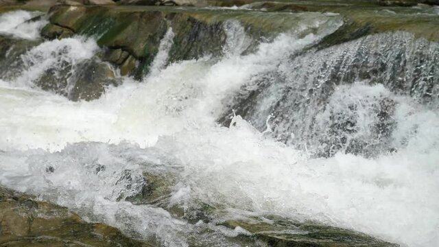 Mighty clean waters overcoming rocky waterfall in the Carpathian mountains 