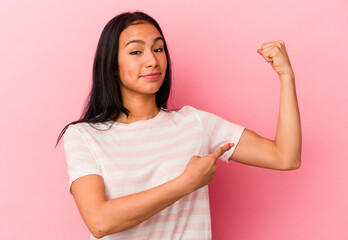 Young Venezuelan woman isolated on pink background showing strength gesture with arms, symbol of feminine power
