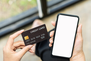 young woman holding smartphone with blank screen and credit card in office Enter your credit card information into the app or website to order online and pay through Internet Banking.