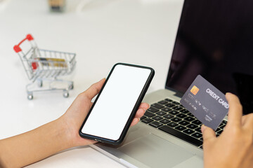 young woman holding smartphone with blank screen and credit card in office Enter your credit card information into the app or website to order online and pay through Internet Banking.