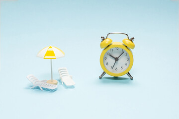 Time to travel. Sun lounger, umbrella and alarm clock.