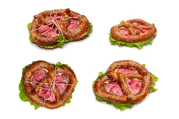 Pretzel with salami and lettuce isolated on a white background.