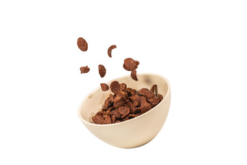 Chocolate corn flakes falling to the white bowl isolated on white. Motion.