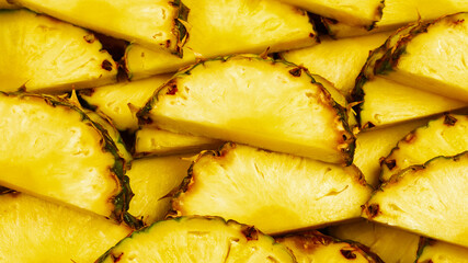 Pineapple juicy yellow slices background. Top view.