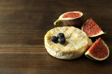 Concept of tasty food with grilled camembert on wooden background