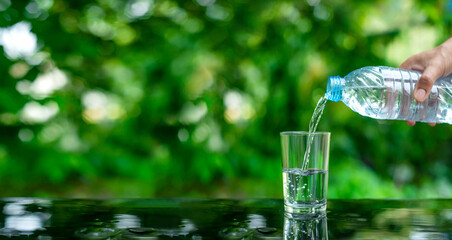 Water flows into a glass placed on a wooden bar.
