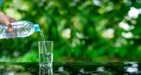 Water flows into a glass placed on a wooden bar.