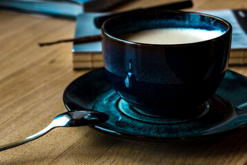 Cup of cappuccino on a saucer with a spoon